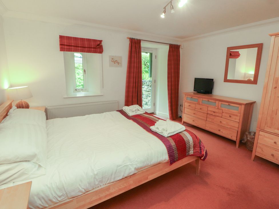 A bedroom with a double bed and furniture at Winster Fields in Cartmel Fell near Windermere