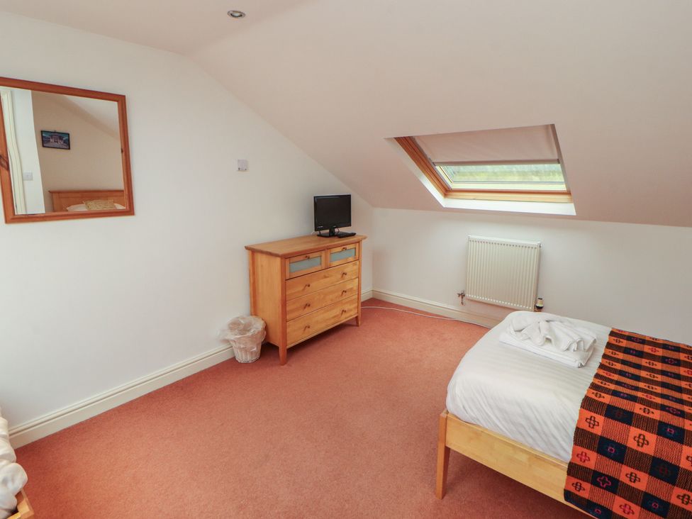 A bedroom with a bed and dresser at Winster Fields in Cartmel Fell near Windermere
