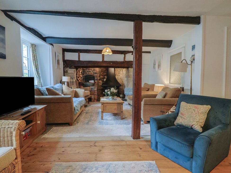 A living room with a sofa and a coffee table at Church Farmhouse in Winsham