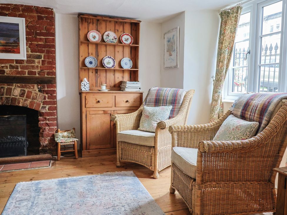 A living room with a fireplace and two armchairs at Church Farmhouse in Winsham