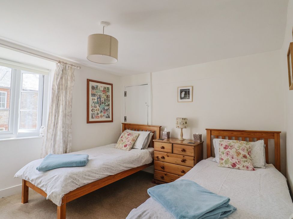 A bedroom with two beds and a dresser at Church Farmhouse in Winsham