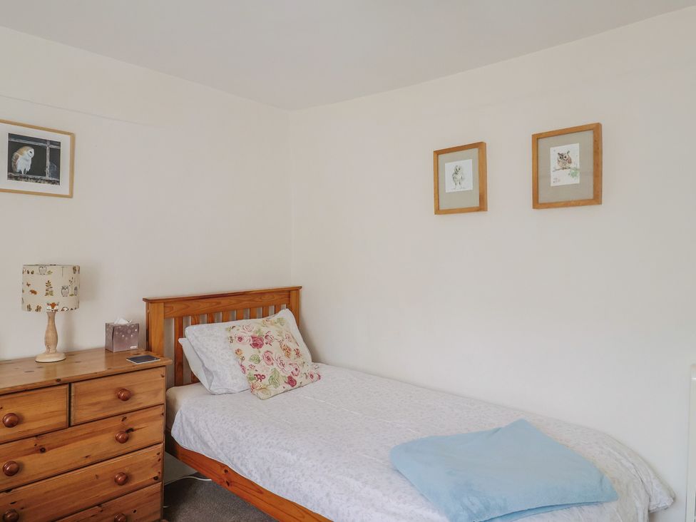 A bedroom with a single bed and a dresser at Church Farmhouse in Winsham
