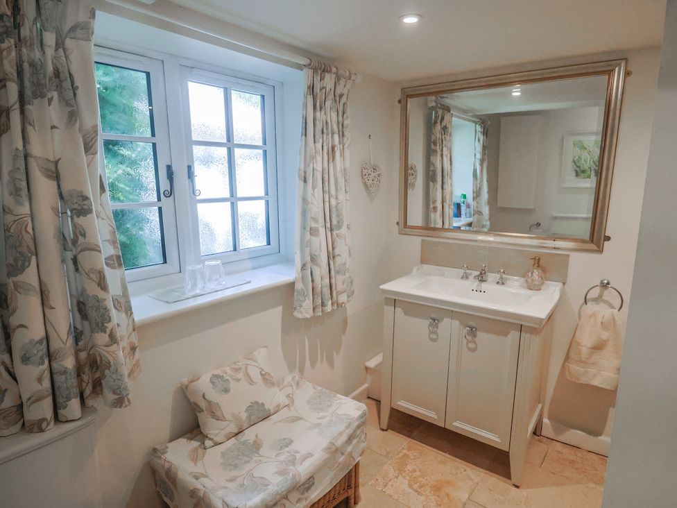 A bathroom with a sink and a mirror at Church Farmhouse in Winsham