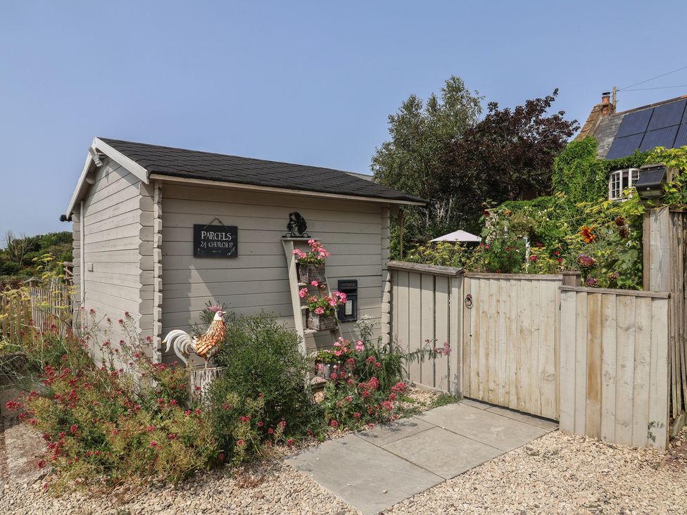 A parcel box and gate with flowers in the garden at Church Farmhouse in Winsham