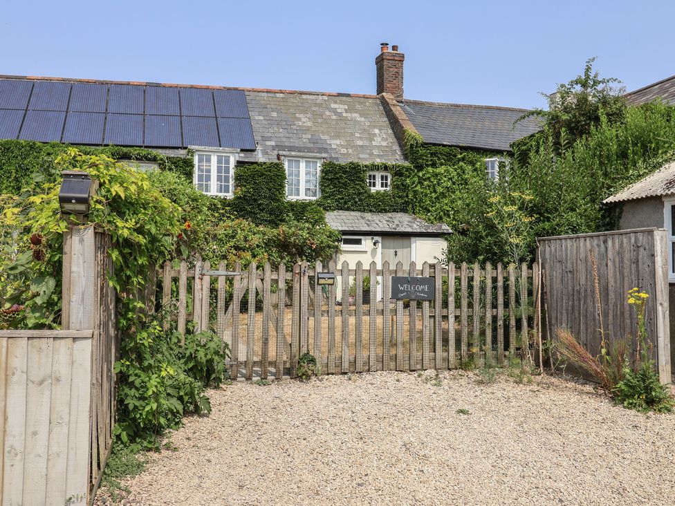 An entrance with a fence and welcome sign at Church Farmhouse in Winsham