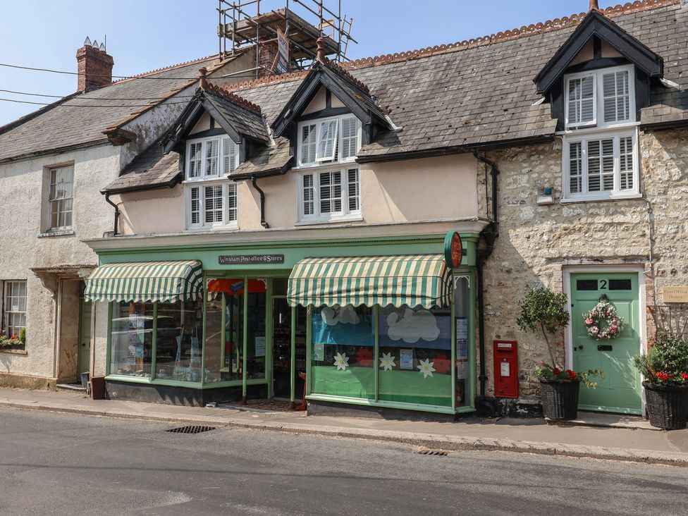 A post office store with green and white awnings in Winsham