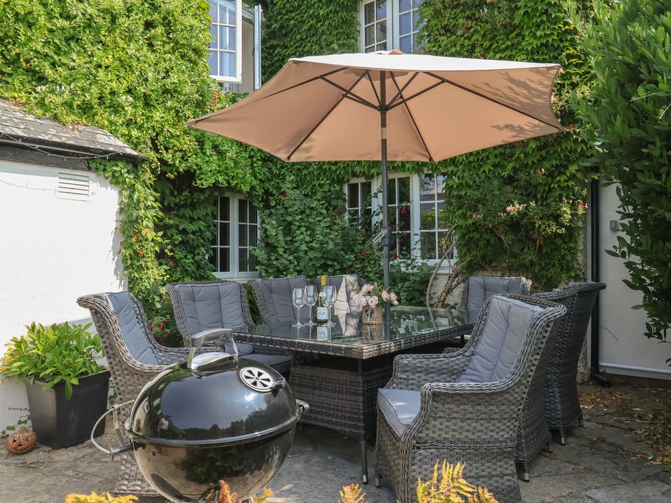 A garden with a dining table and chairs at Church Farmhouse in Winsham