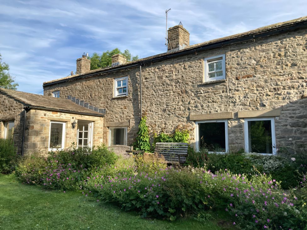 A stone house with garden and benches at The Old Post Office in Marrick near Reeth