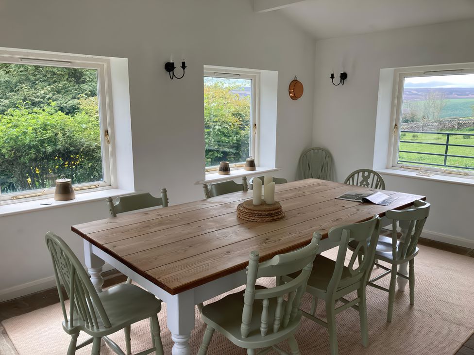 A dining room with a wooden table and chairs at The Old Post Office in Marrick near Reeth