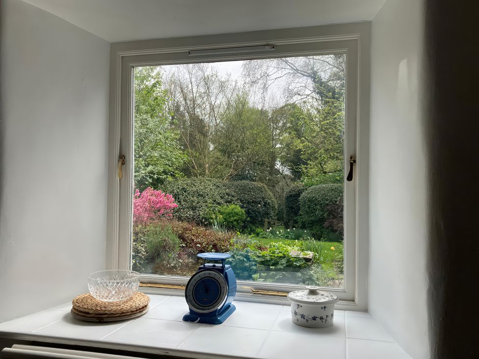 A window view of a garden with plants and a scale at the Old Post Office in Marrick near Reeth