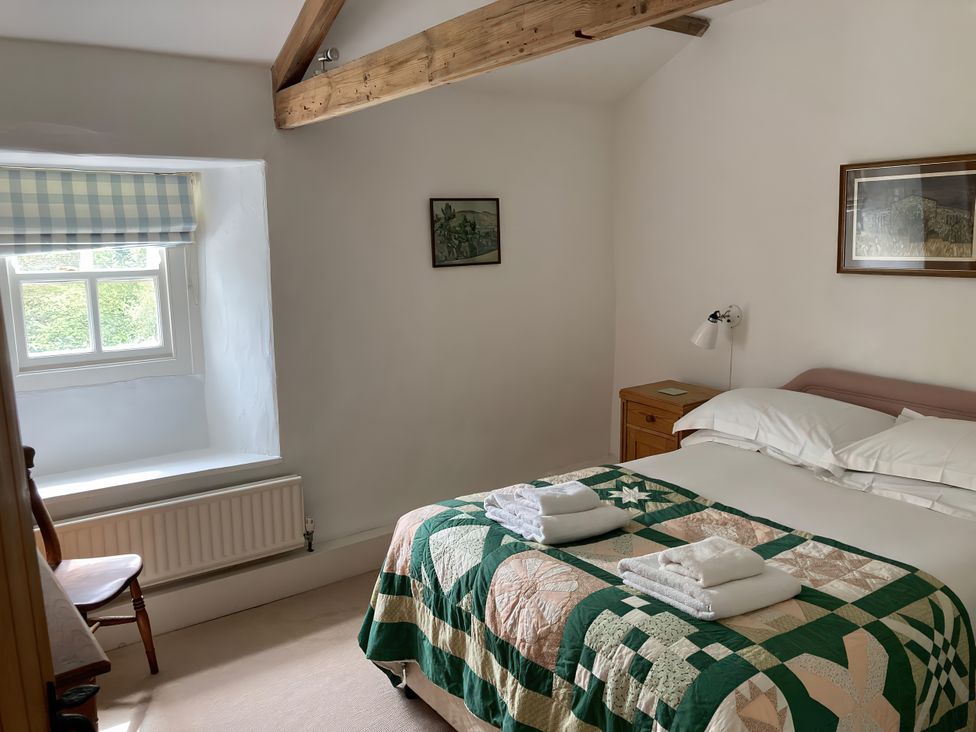 A bedroom with a bed and quilt at The Old Post Office in Marrick near Reeth