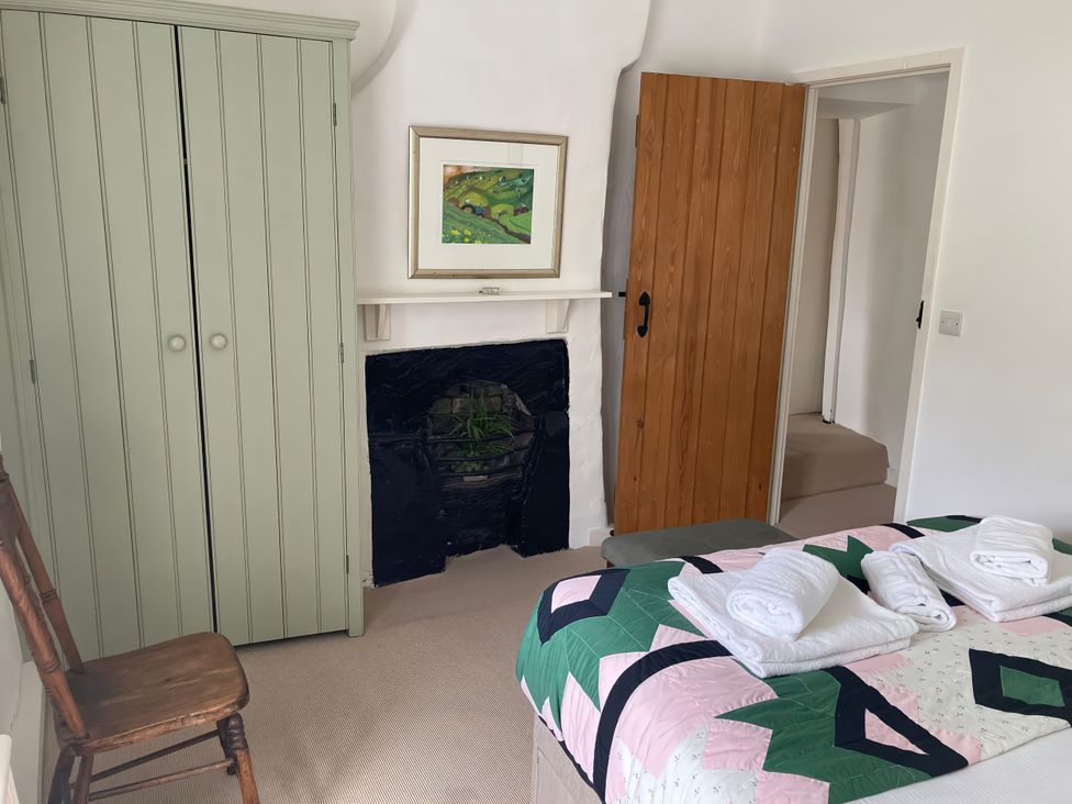 A bedroom with a bed and wardrobe at The Old Post Office in Marrick near Reeth