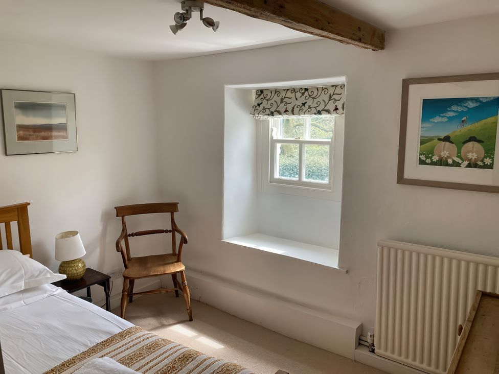 A bedroom with a bed and window in Old Post Office Marrick near Reeth
