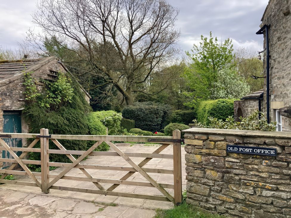 A garden view with a gate and stone wall at the Old Post Office in Marrick near Reeth