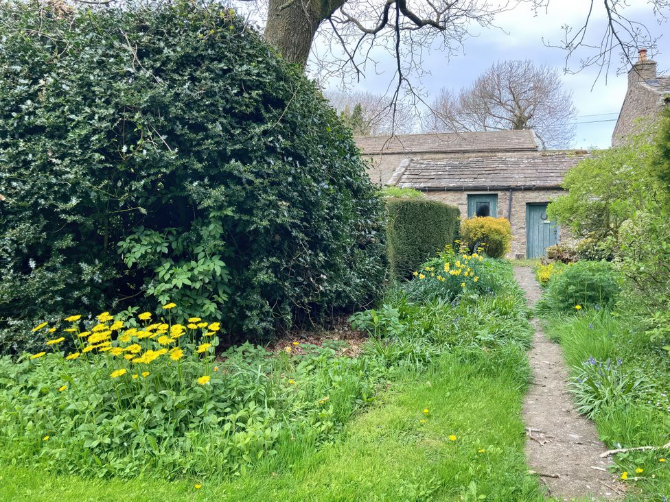 A garden with a pathway and flowers at The Old Post Office in Marrick near Reeth