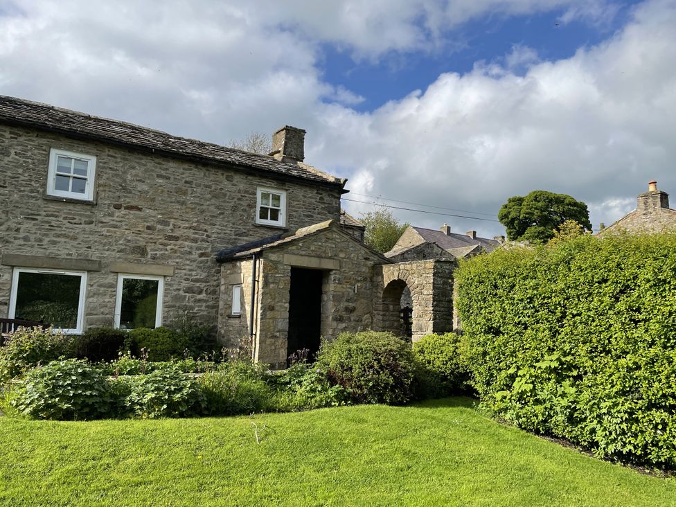 A house with stone walls and greenery at The Old Post Office in Marrick near Reeth