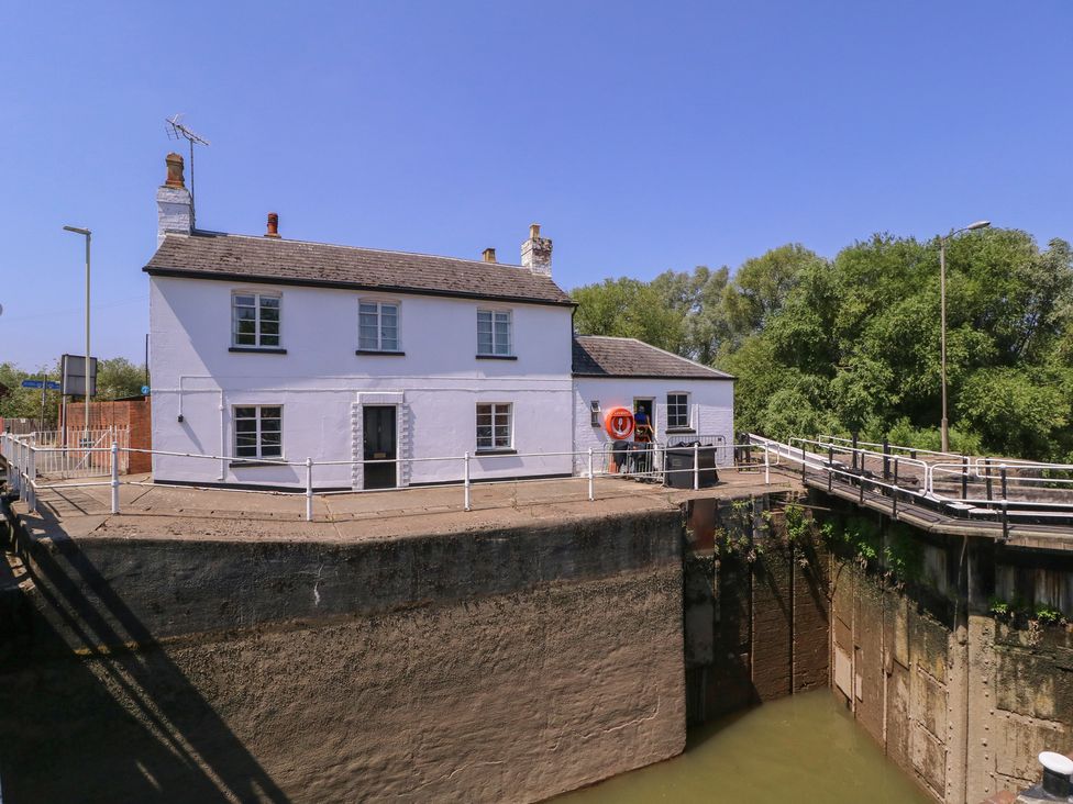 A house by a dock with a life buoy and bridge at The Lock House in Gloucester