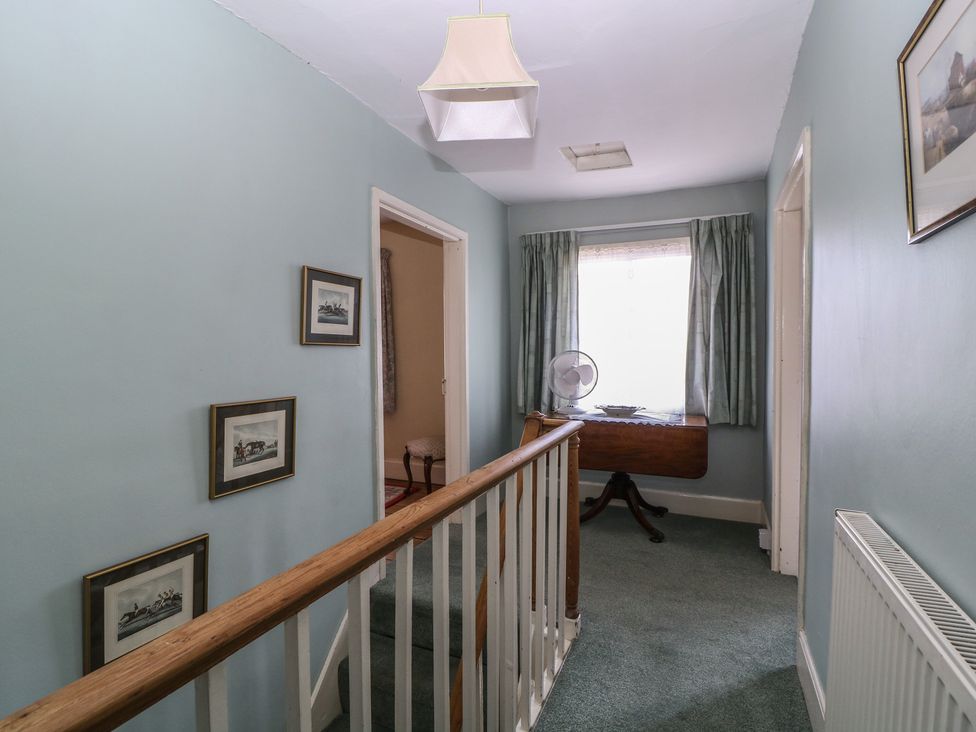 A hallway with a railing and photographs at The Lock House in Gloucester