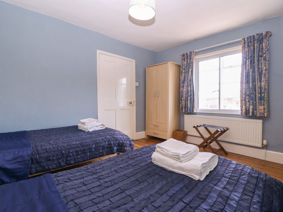 A bedroom with two beds and a wardrobe at The Lock House in Gloucester