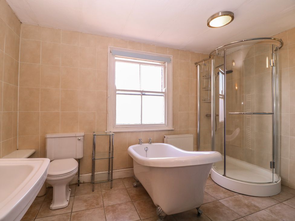 A bathroom with a bathtub, shower, toilet, and sink at The Lock House in Gloucester