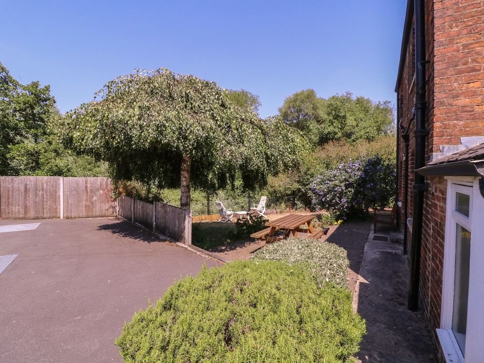 A garden with a tree, table, and chairs at The Lock House in Gloucester