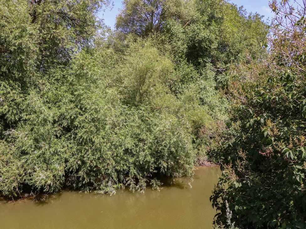 A view of a river surrounded by trees at The Lock House in Gloucester