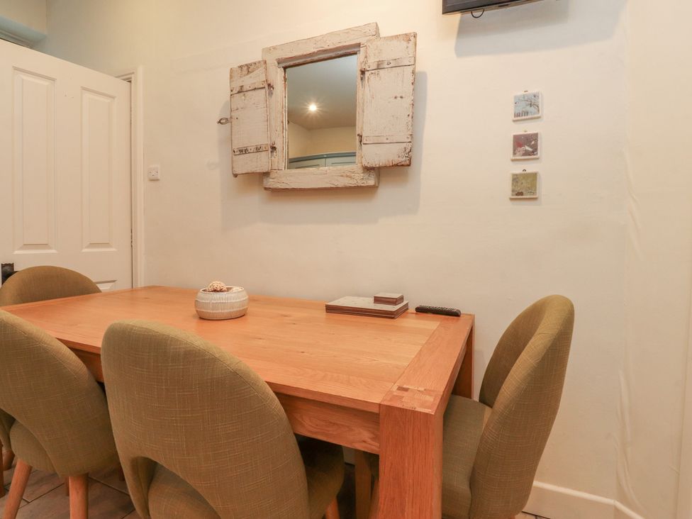 A dining room with a table and chairs at Canalside Cottage Farnhill near Skipton