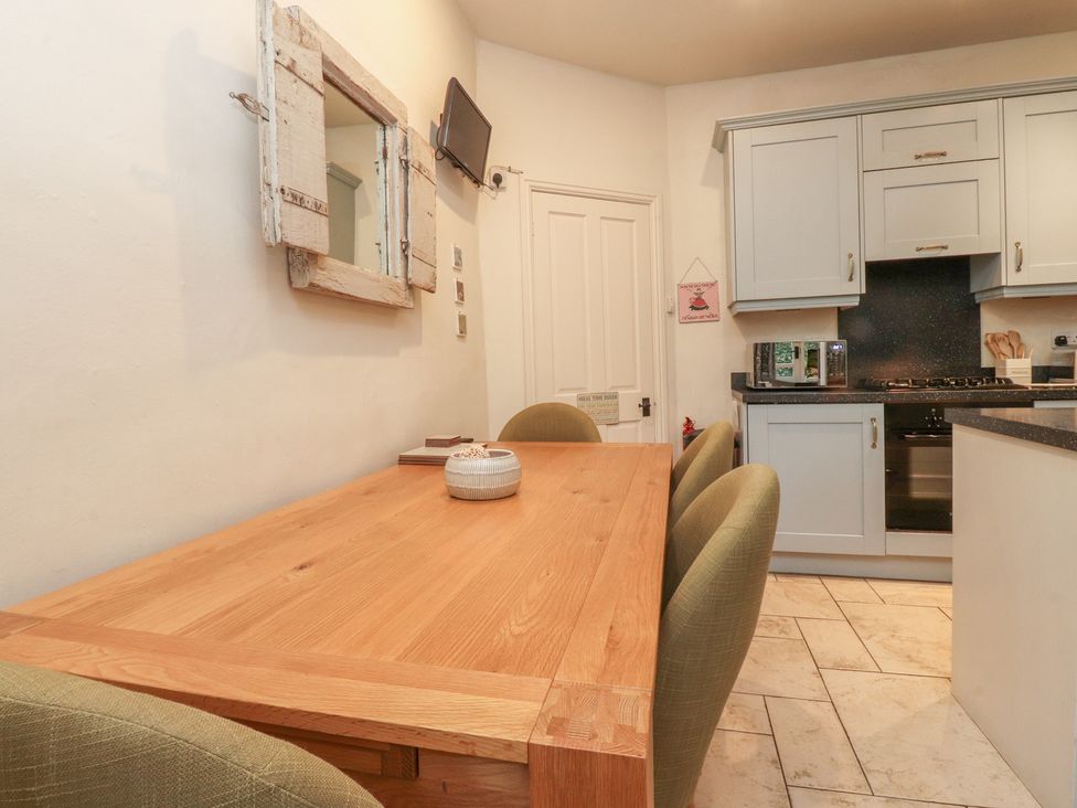 A kitchen with a dining table and chairs at Canalside Cottage in Farnhill near Skipton
