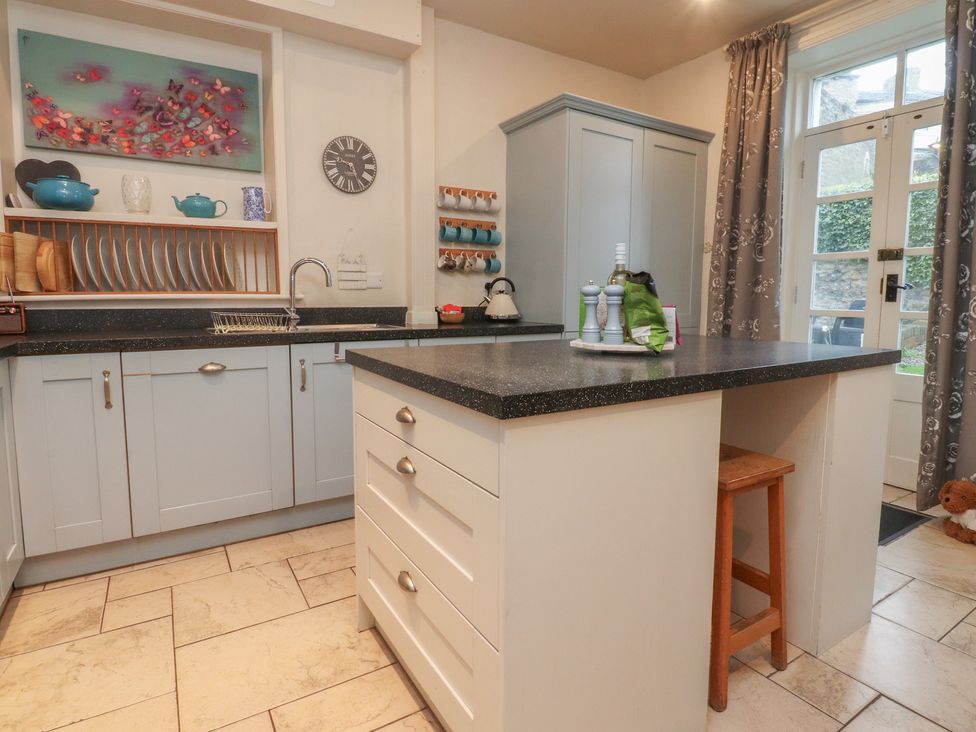 A kitchen with cabinets and a sink at Canalside Cottage in Farnhill near Skipton