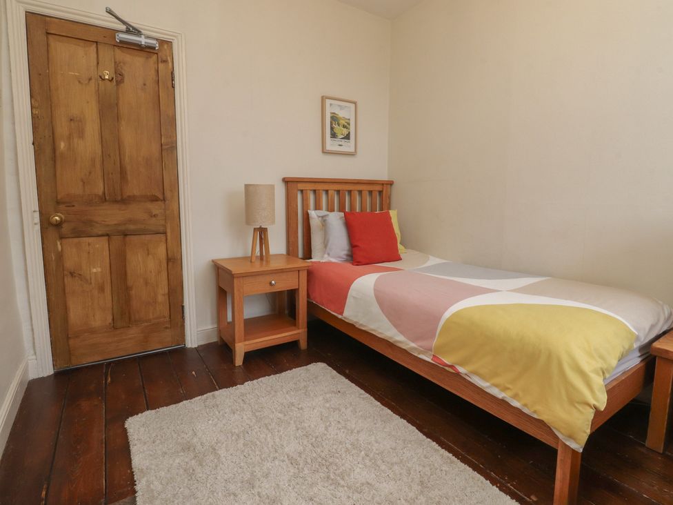 A bedroom with a bed and a side table at Canalside Cottage in Farnhill near Skipton