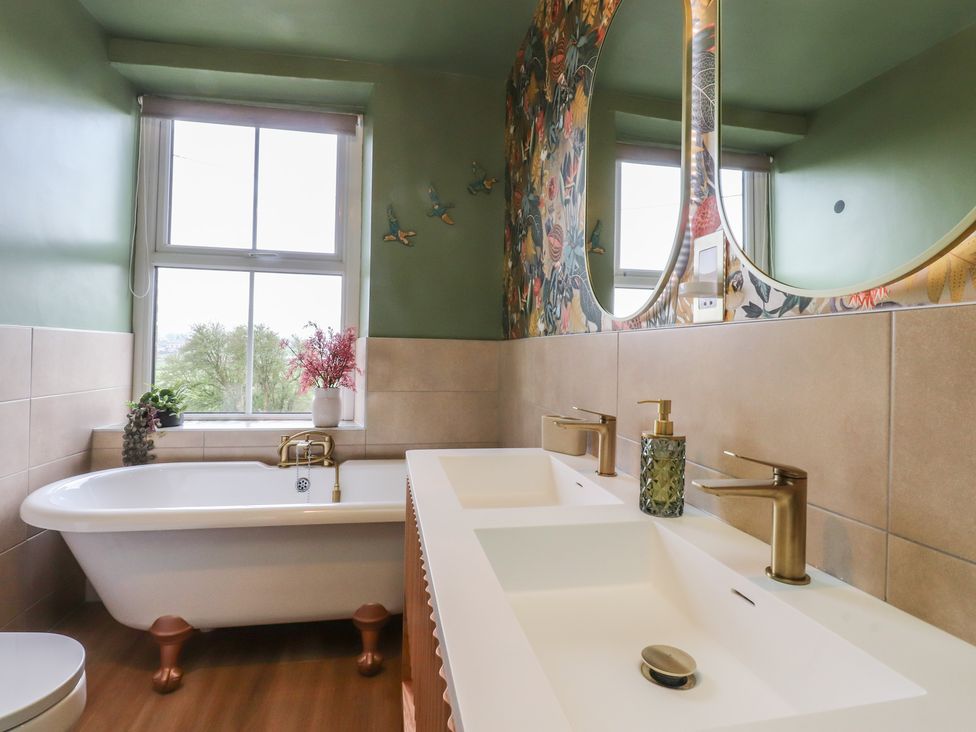 A bathroom with a bathtub and sink at Canalside Cottage in Farnhill near Skipton