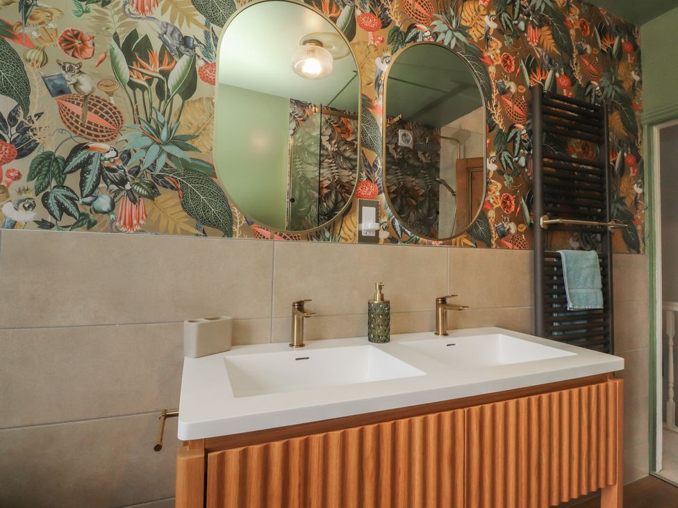 A bathroom with sinks and mirrors at Canalside Cottage in Farnhill near Skipton