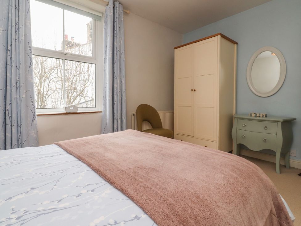 A bedroom with a bed and a wardrobe at Canalside Cottage Farnhill near Skipton