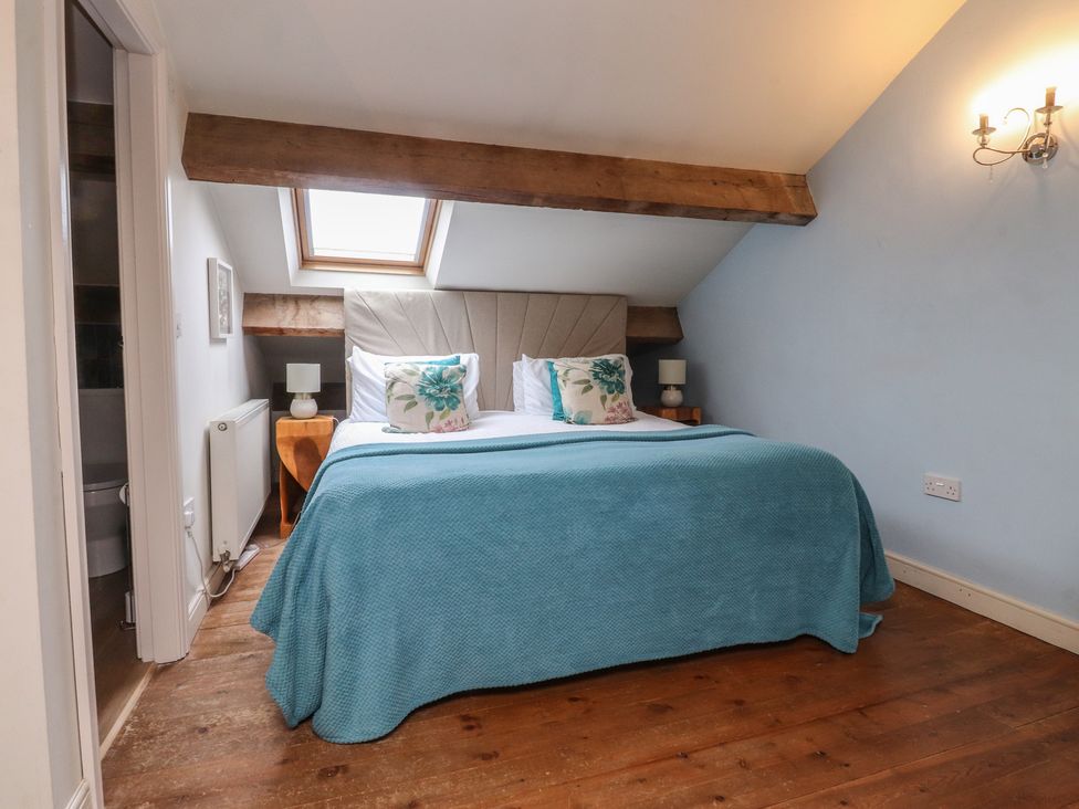 A bedroom with a bed and bedside lamps at Canalside Cottage in Farnhill near Skipton