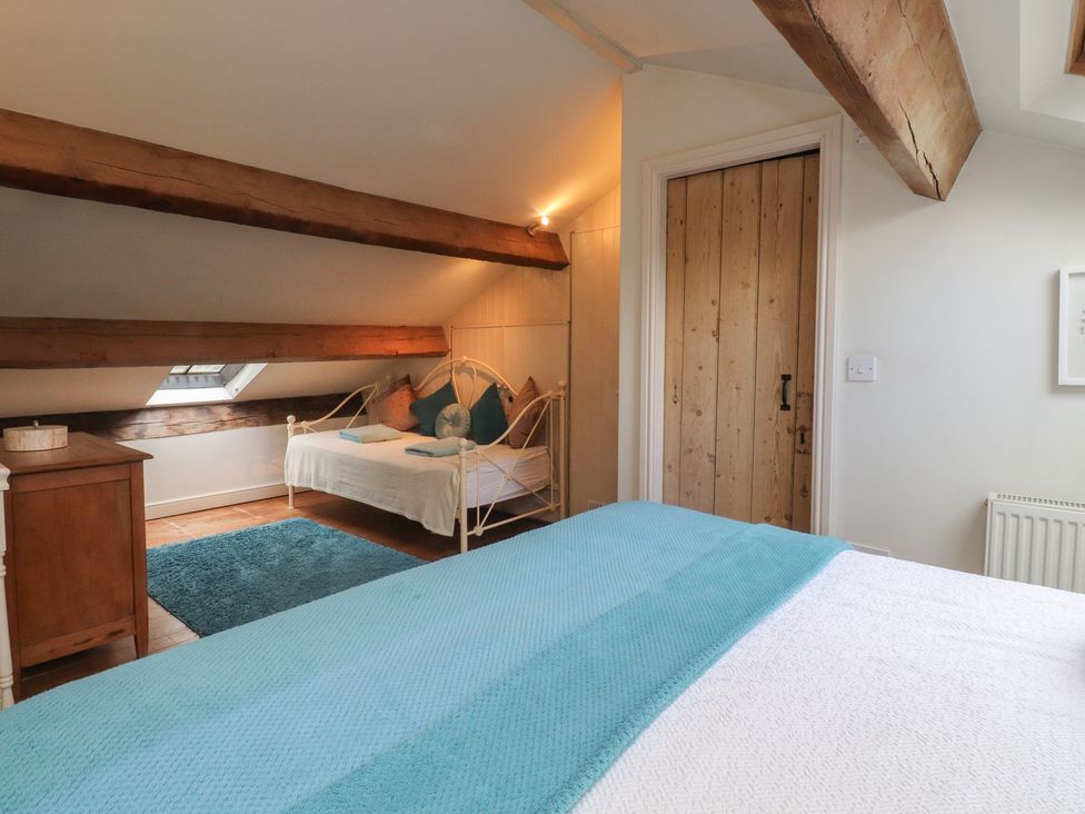 A bedroom with a double bed and a single bed at Canalside Cottage in Farnhill near Skipton
