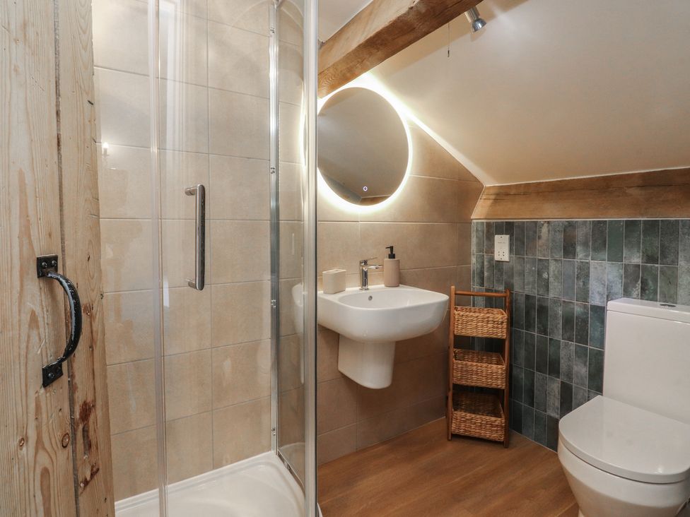 A bathroom with a shower, sink, and toilet at Canalside Cottage, Farnhill near Skipton