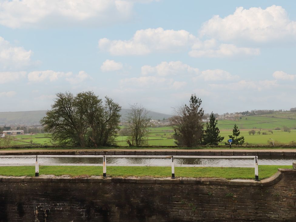 A landscape with a canal and trees at Canalside Cottage Farnhill near Skipton