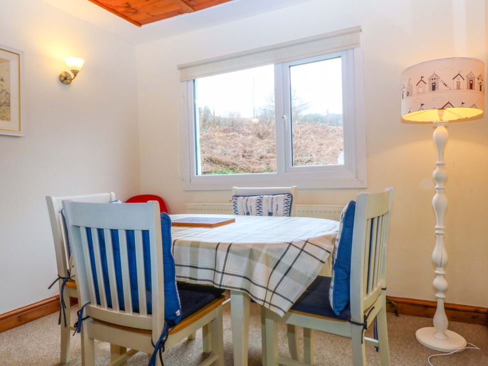 A dining room with a table and chairs at Min Y Traeth in Bull Bay