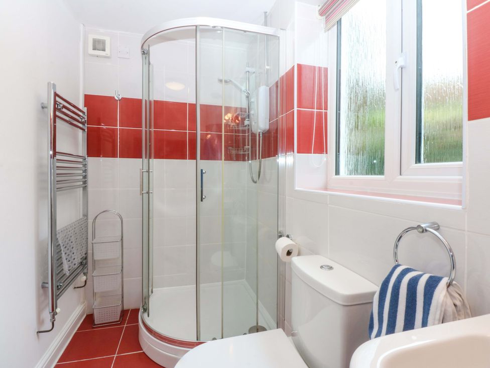 A bathroom with a shower and toilet at Min Y Traeth in Bull Bay