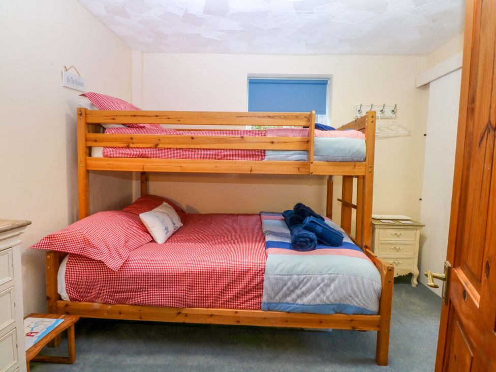 A bedroom with a bunk bed and bedside furniture at Min Y Traeth in Bull Bay