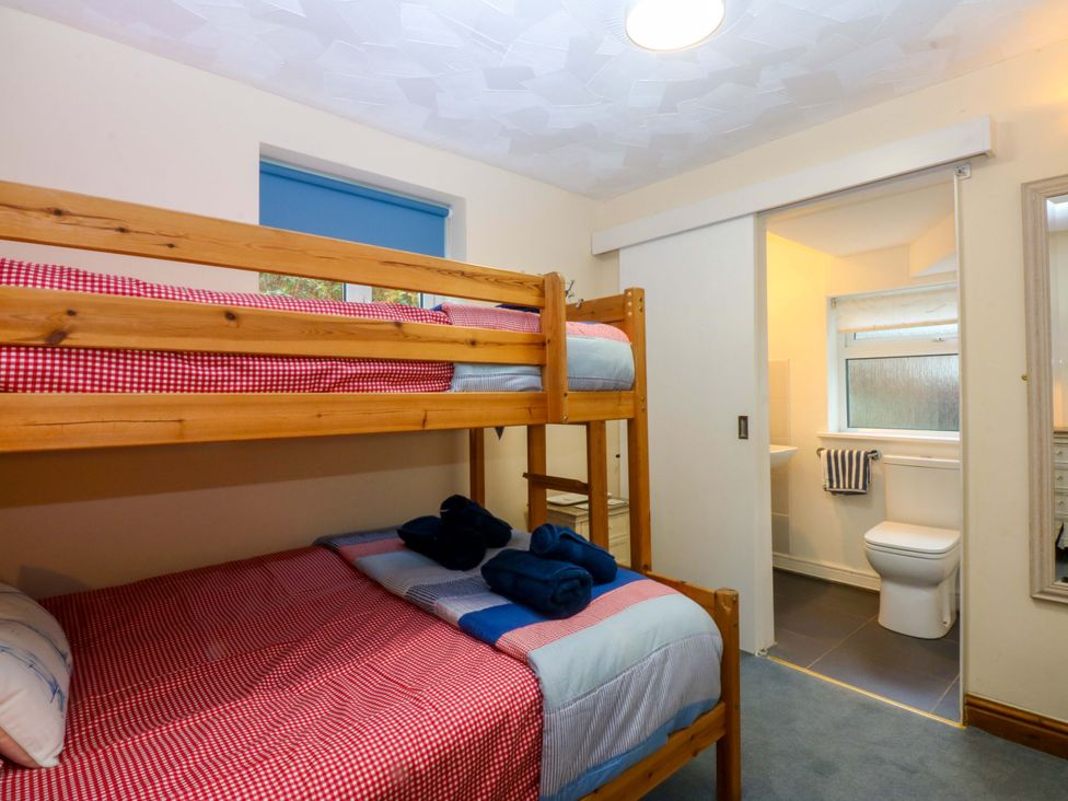 A bedroom with bunk bed and single bed at Min Y Traeth in Bull Bay