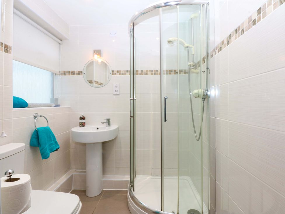 A bathroom with a shower and sink at Min Y Traeth in Bull Bay