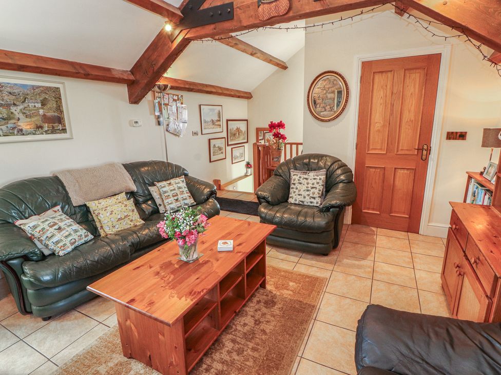 A living room with sofas and a coffee table at Piggery Cottage Wigton