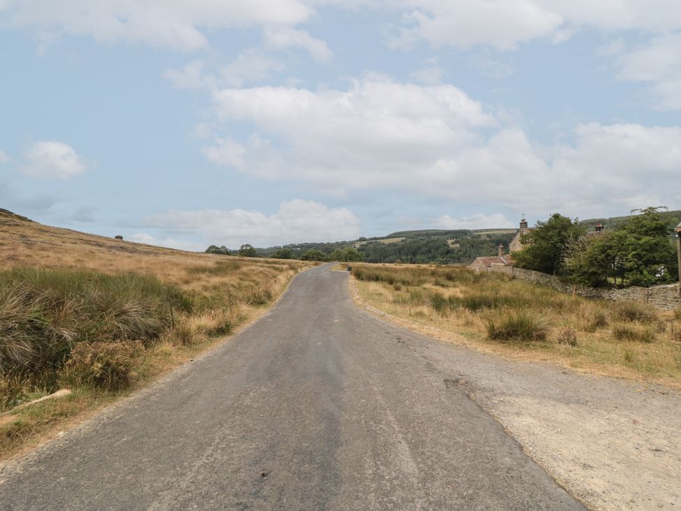 A road surrounded by grass and houses at 1 Brow Cottages in Green End near Goathland