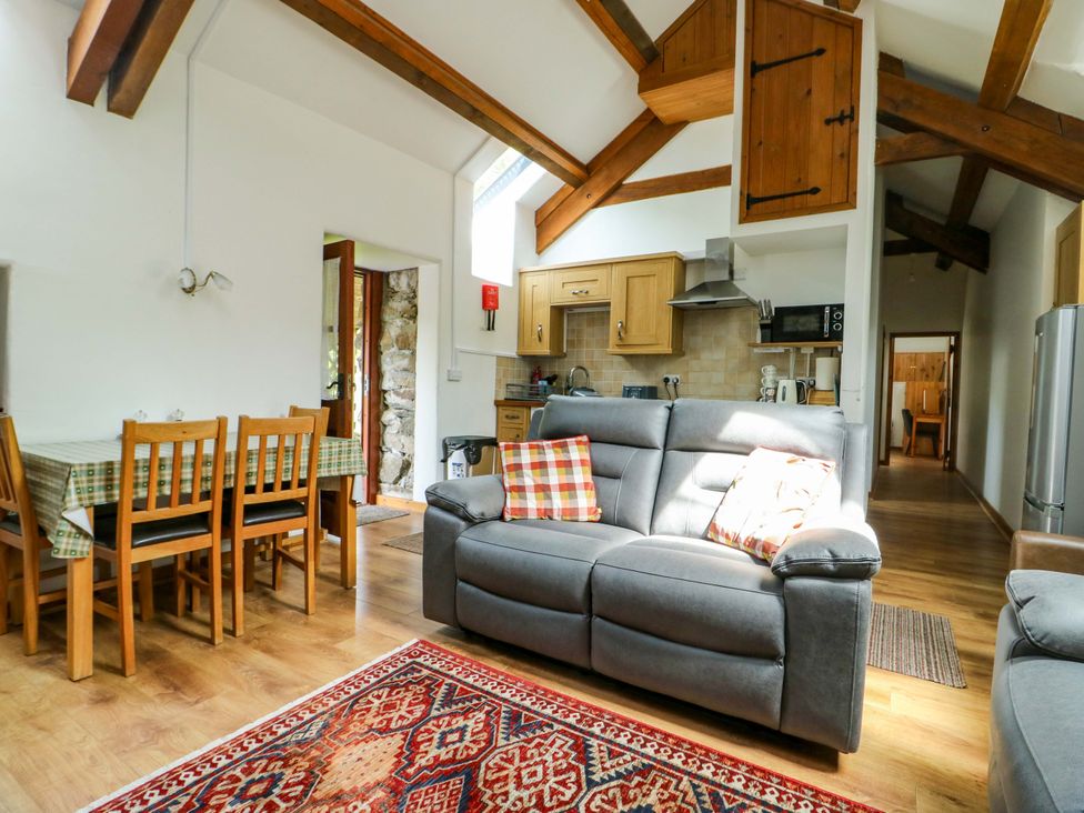 A living room with a sofa and dining area at Bythyn Ddol Hafod in Capel Curig
