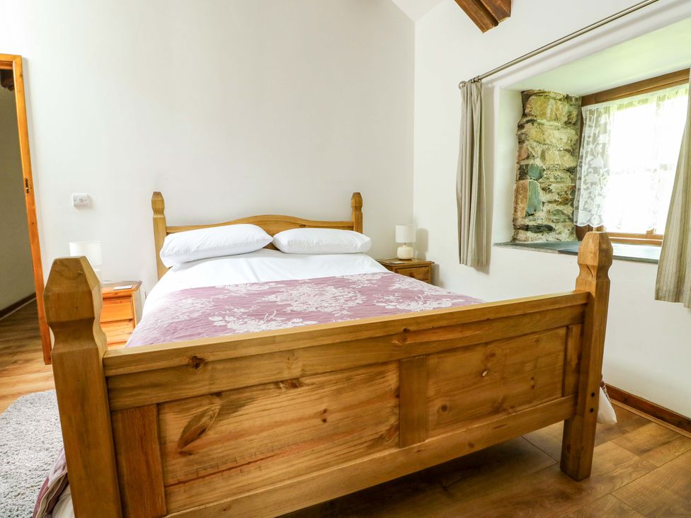 A bedroom with a bed and bedside table at Bythyn Ddol Hafod in Capel Curig
