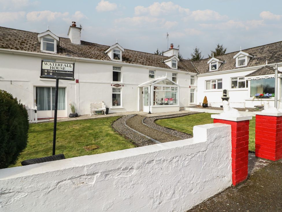 An exterior view of a house with a garden and sign at Waterfall House in Dunmanway, County Cork