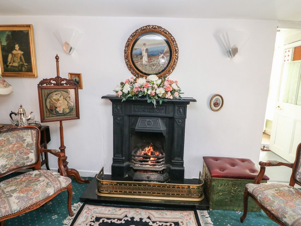 A living room with a fireplace and floral arrangement at The Farmhouse in Dunmanway, County Cork