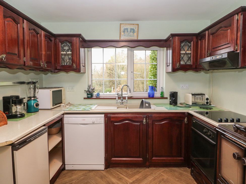 A kitchen with wooden cabinets and appliances at The Farmhouse in Dunmanway, County Cork