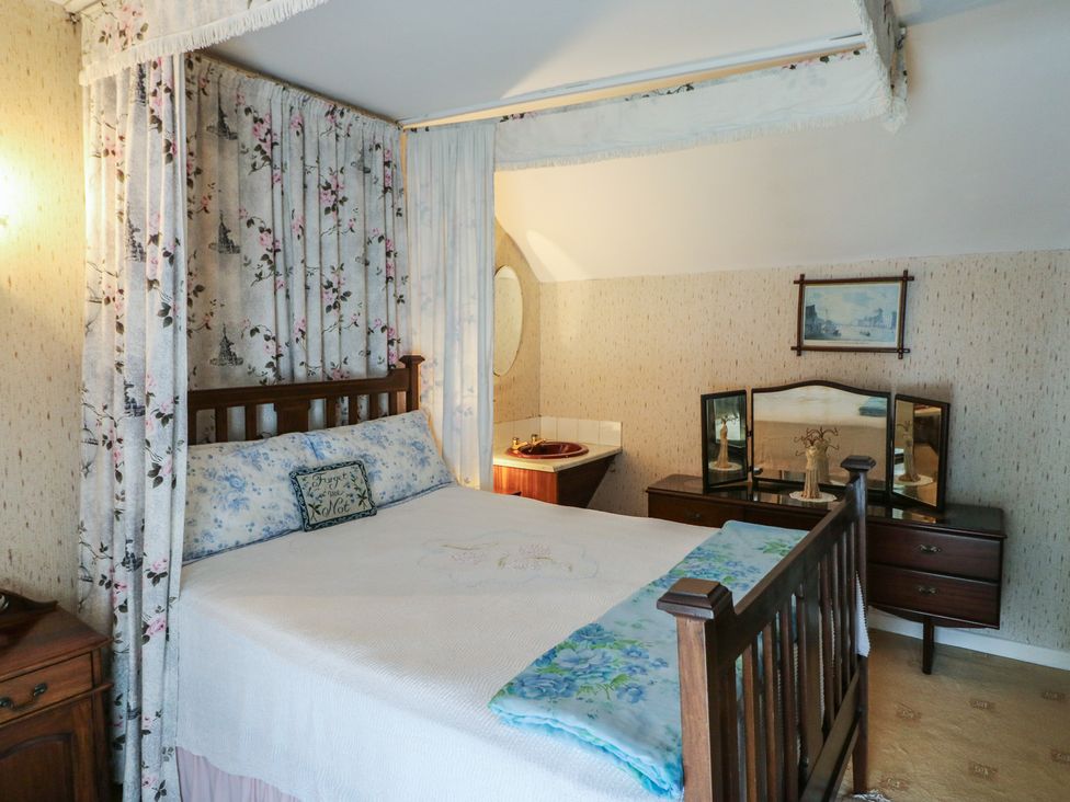 A bedroom with a bed and dressing table at The Farmhouse in Dunmanway, County Cork